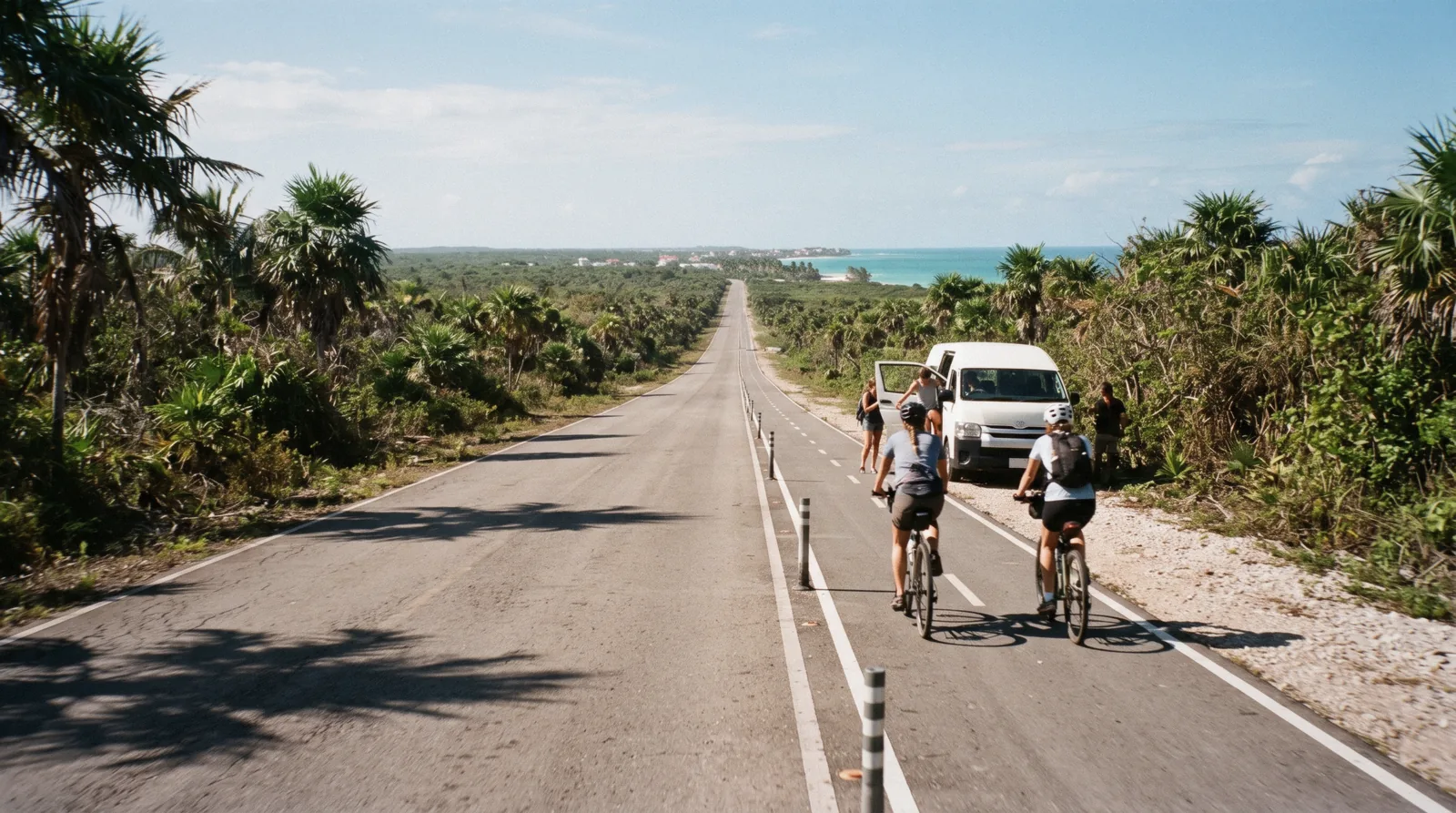 Cyclists and a shared colectivo van on the road between town and the beach, getting around Tulum, Tulum Mexico